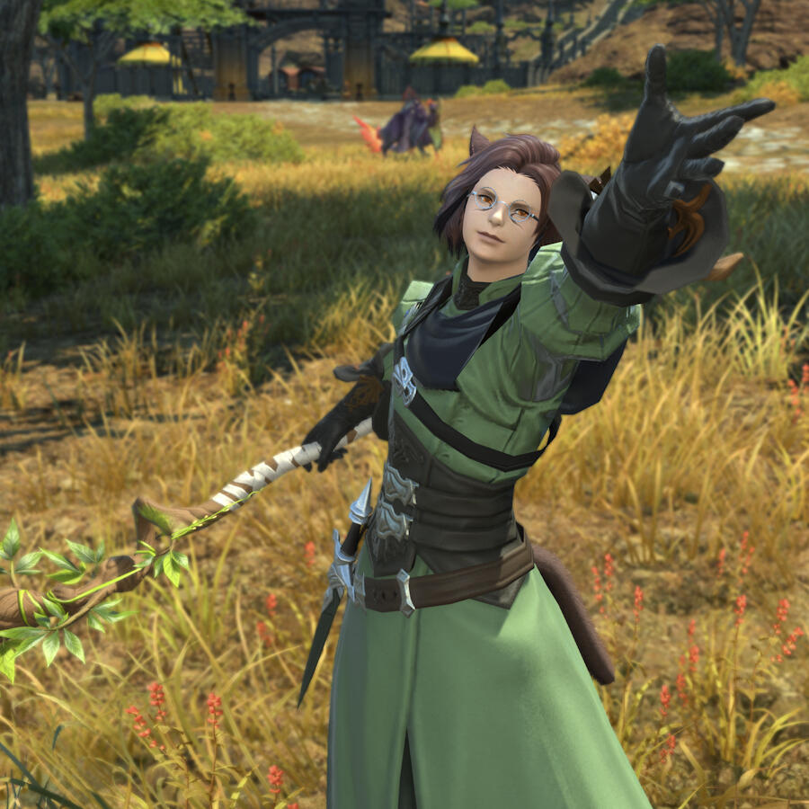 Kheda in green mage robes with his hand reaching upwards. He looks past the viewer. He holds a wooden conjurer's staff at his side.